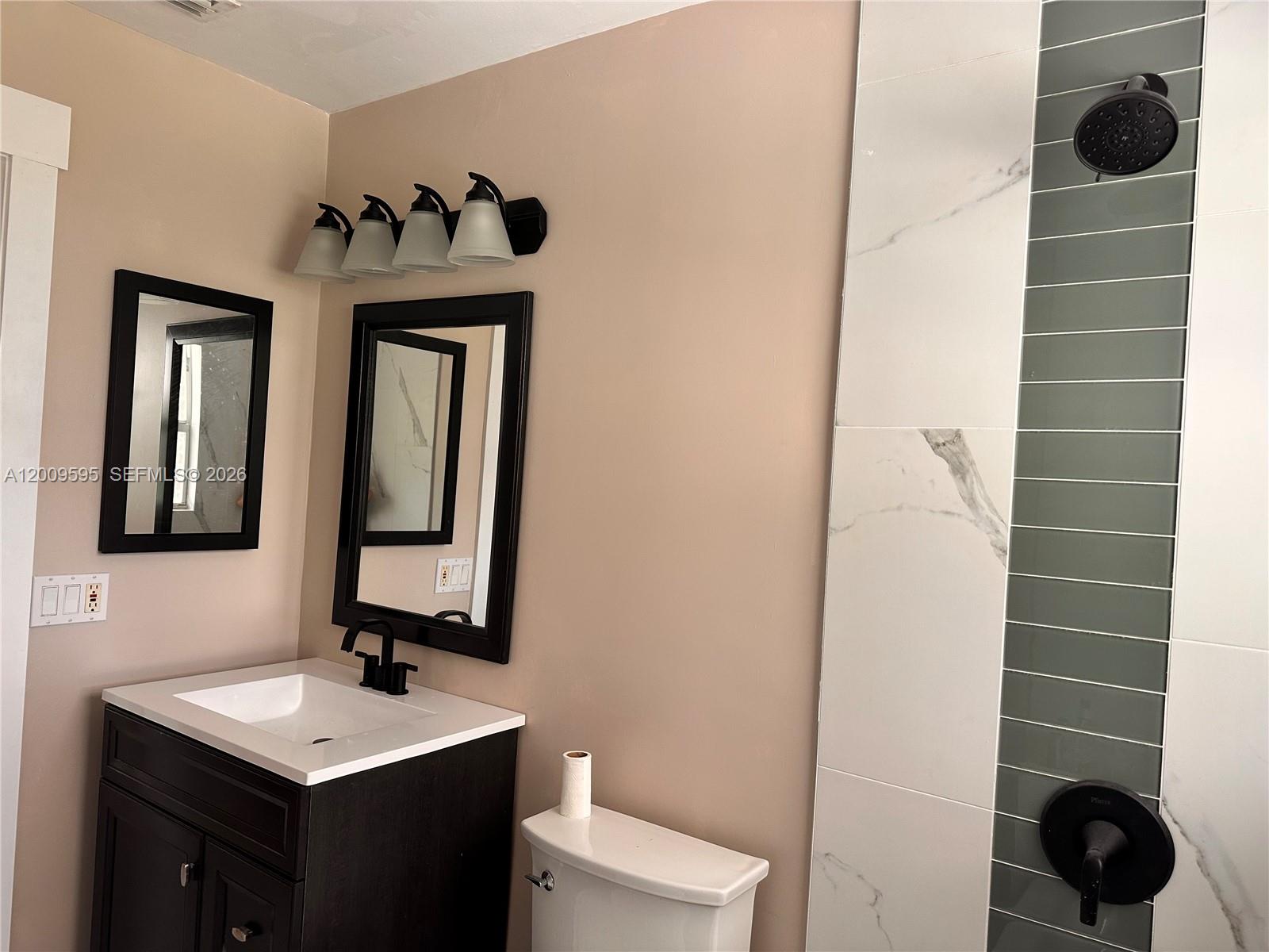 3614 Everglades Road Palm Beach Gardens, FL 33410 - Photo 5 of 9 a bathroom with a toilet sink and mirror