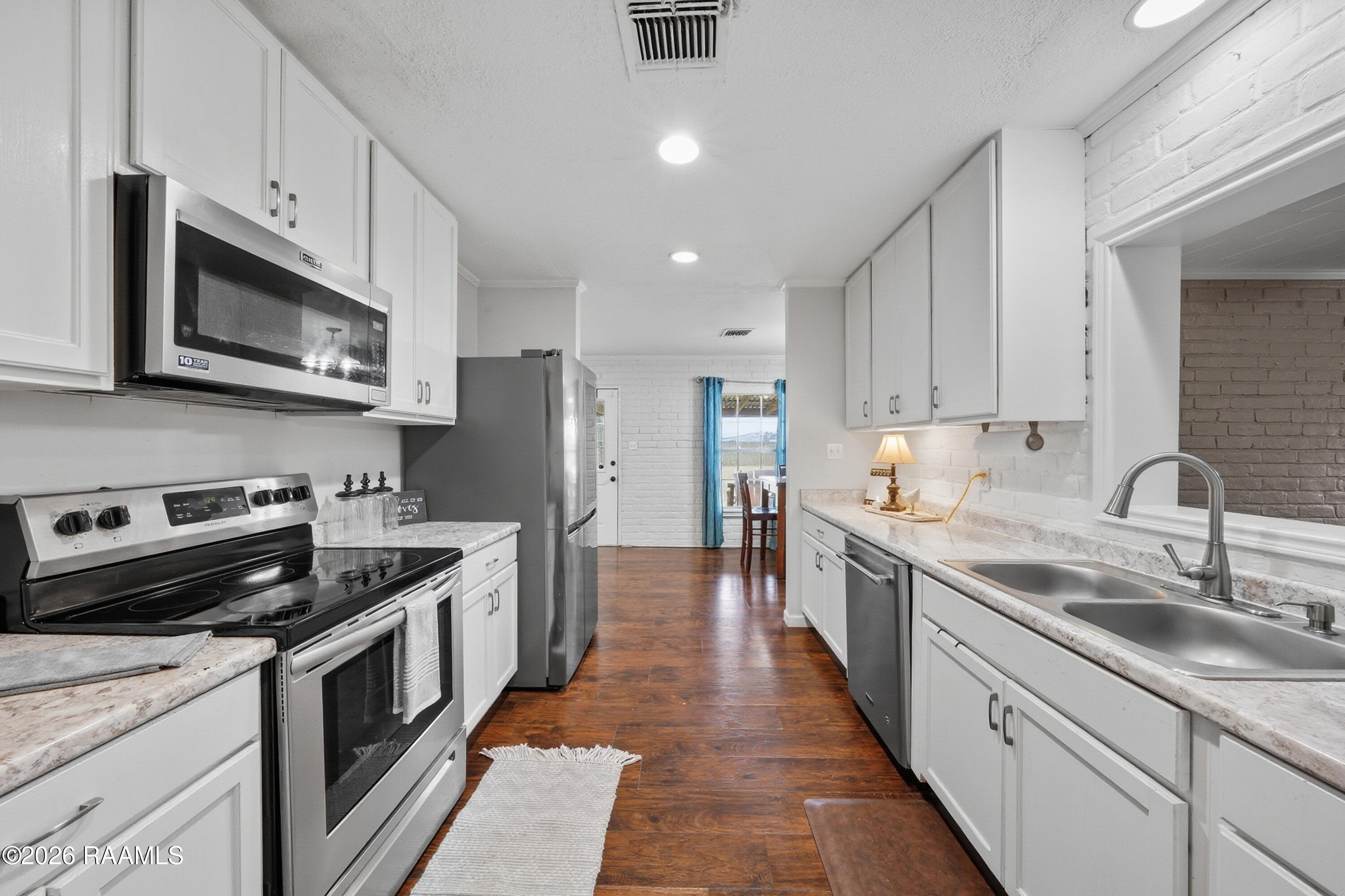 218 Fallis Road Lafayette, LA 70507 - Photo 12 of 28 Fallis kitchen with opening to bonus roo