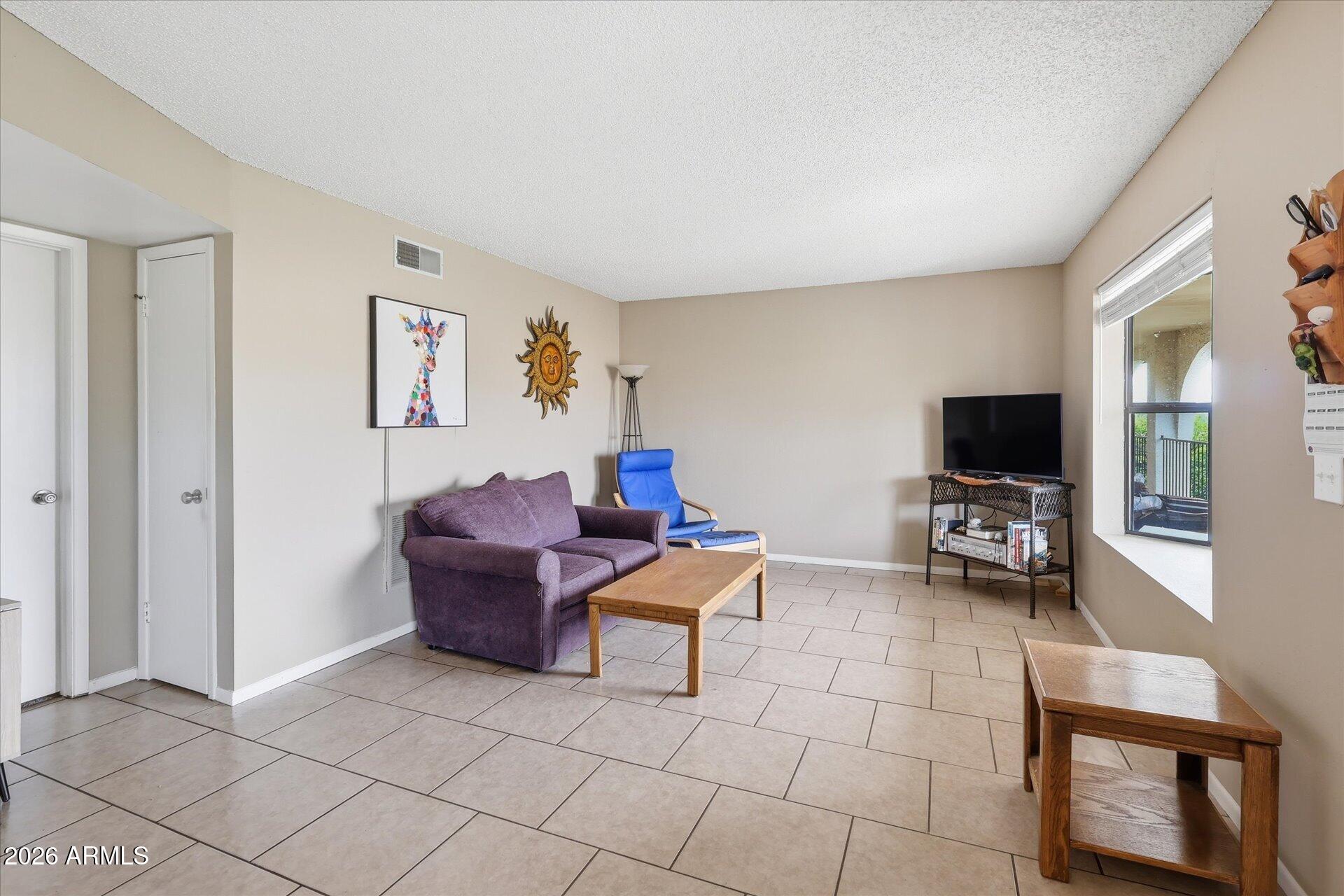 3270 South Goldfield Road, Unit 716 Apache Junction, AZ 85119 - Photo 10 of 36 a living room with furniture and a flat screen tv