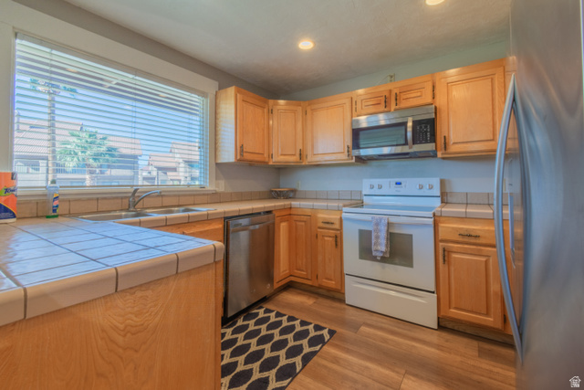860 South Village Road, Unit Y8 St. George, UT 84770 - Photo 2 of 29 Kitchen featuring stainless steel appliances, tile counters, light wood-style floors, and recessed lighting