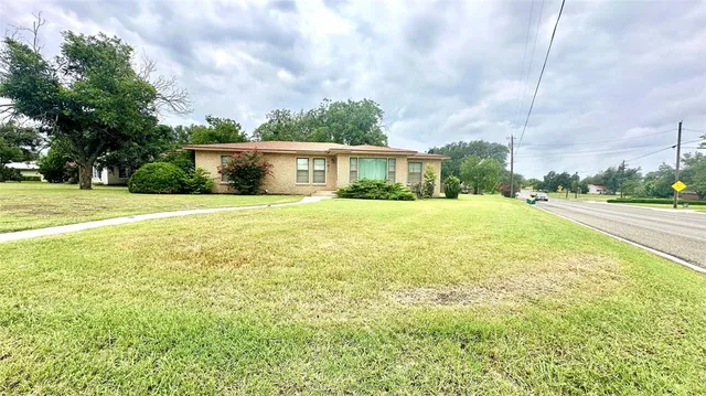 a view of a house with a yard and potted plants