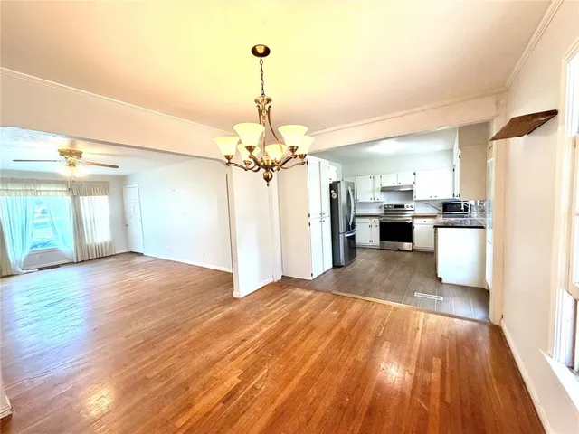 a view of a kitchen with a sink and dishwasher with wooden floor