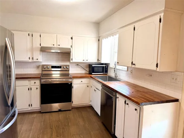a kitchen with stainless steel appliances a sink stove and refrigerator