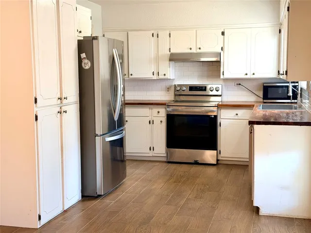 a kitchen with stainless steel appliances a stove a refrigerator and a microwave