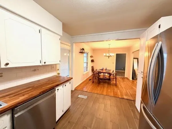 a kitchen with stainless steel appliances a counter top space and a wooden floor
