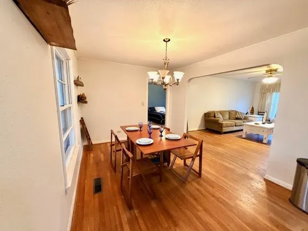 a workspace with furniture wooden floor and a chandelier