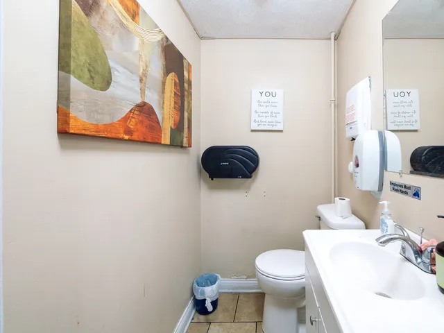 a bathroom with a toilet a sink and mirror