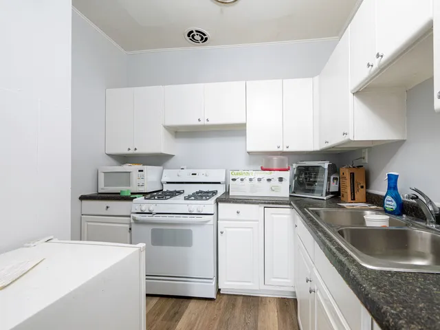 a kitchen with a sink a stove and cabinets