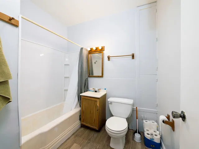 a white toilet sitting next to a bath tub