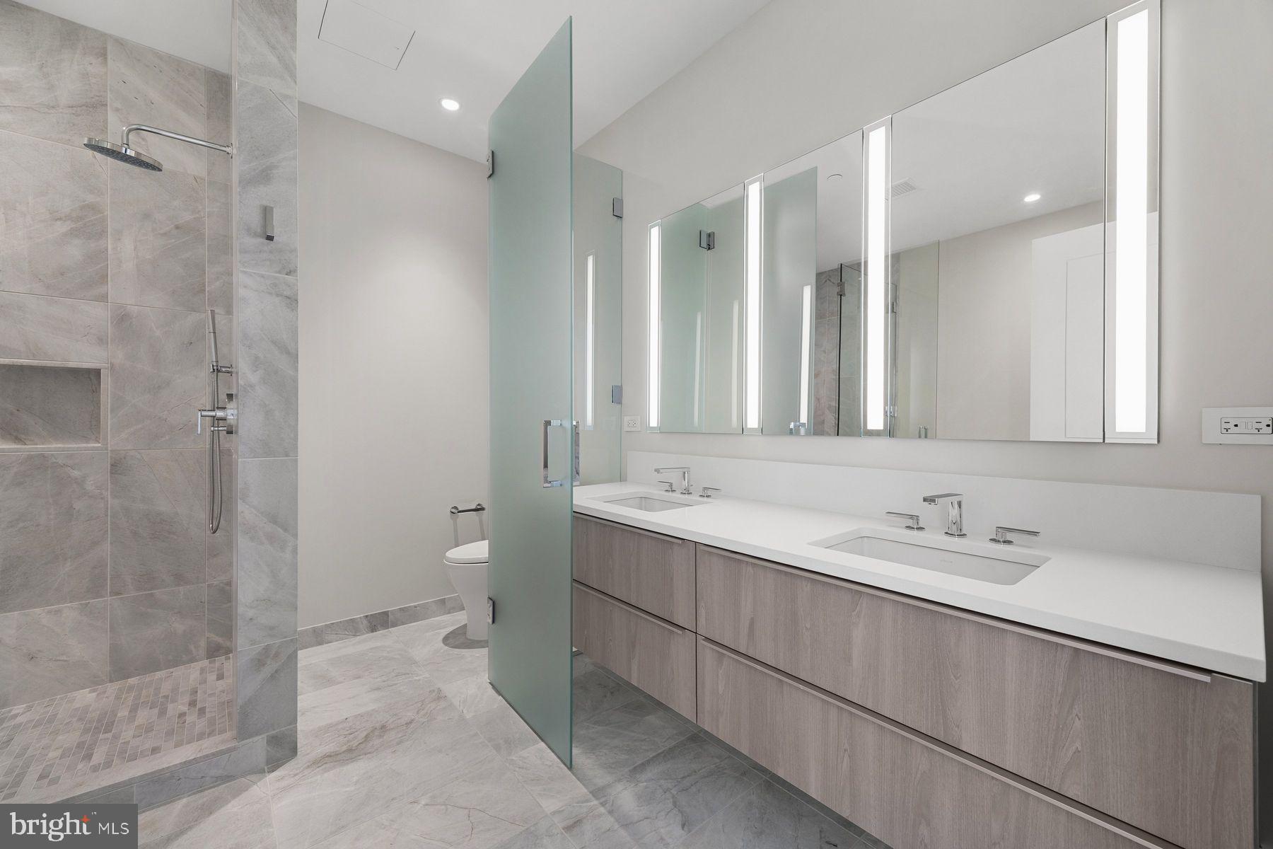 301 South Broad Street, Unit 1902 Philadelphia, PA 19107 - Photo 23 of 44 a bathroom with a double vanity sink mirror and shower