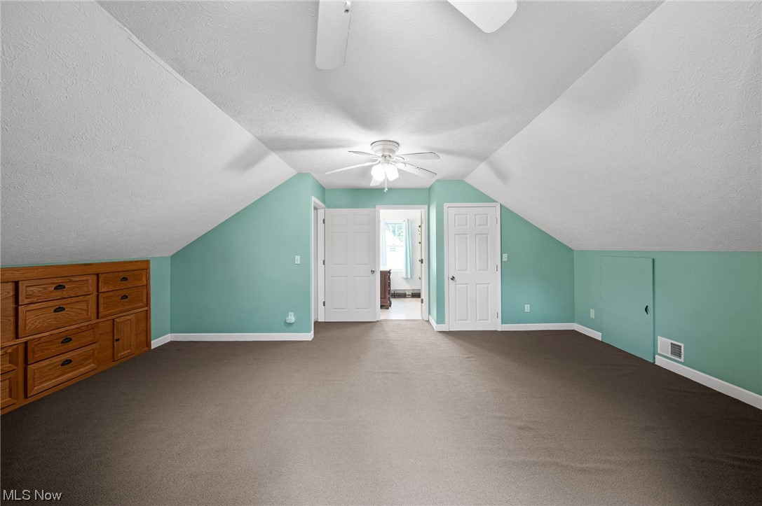 228 Cavalry Road Vermilion, OH 44089 - Photo 27 of 34 Additional living space with ceiling fan, a textured ceiling, lofted ceiling, and carpet flooring