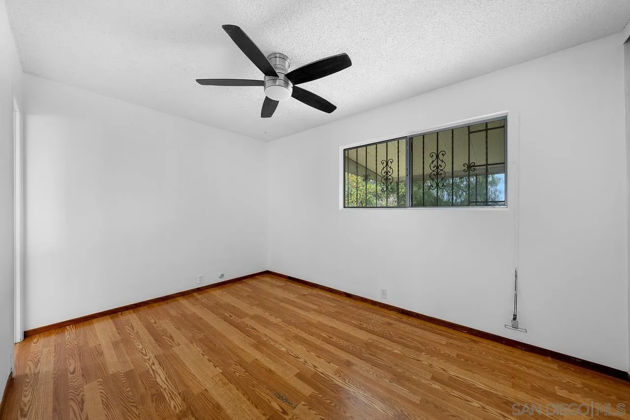 966 27th Street San Diego, CA 92154 - Photo 16 of 33 an empty room with wooden floor fan and windows