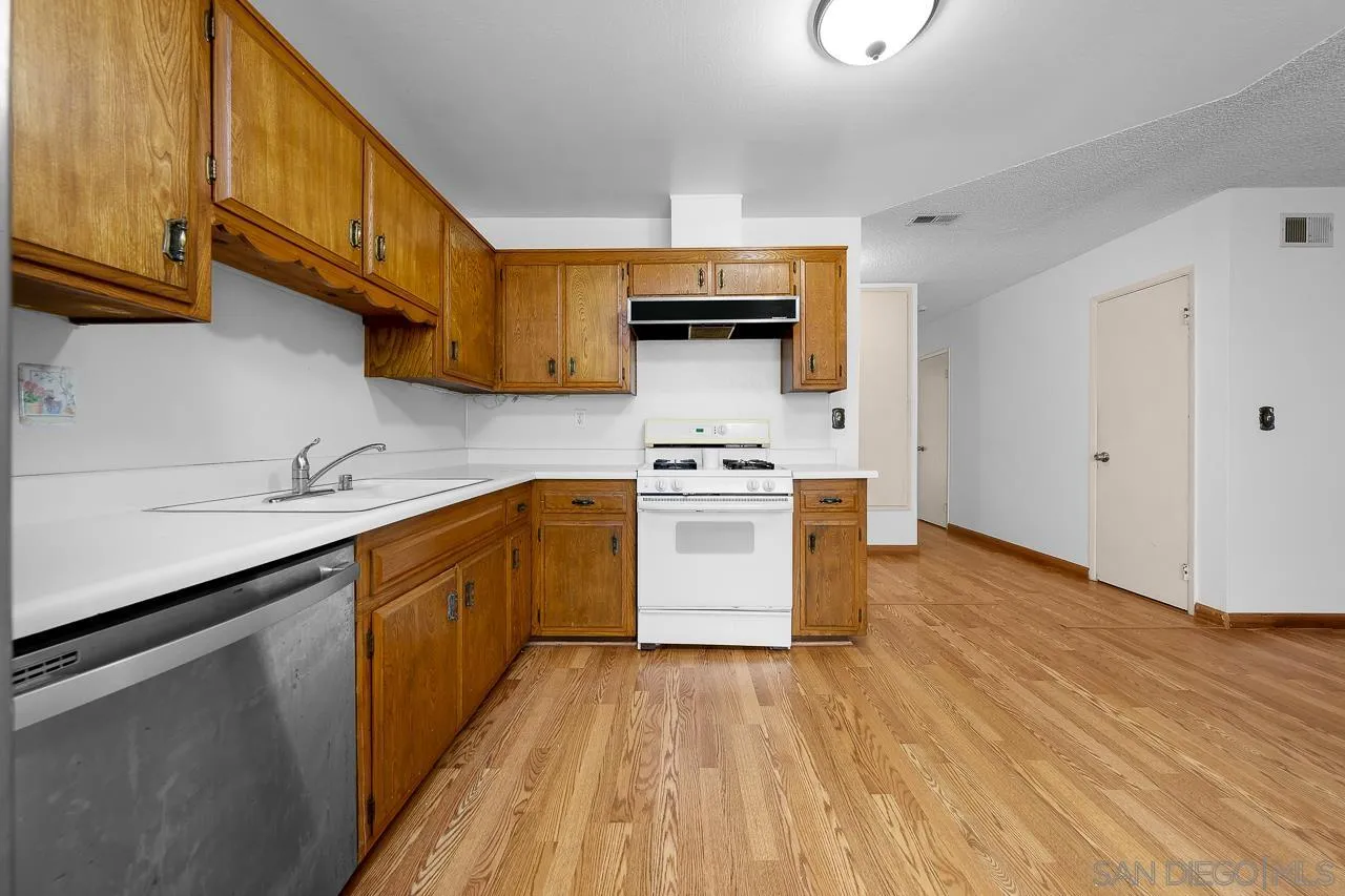 966 27th Street San Diego, CA 92154 - Photo 31 of 33 a kitchen with a sink a stove top oven and wooden floor