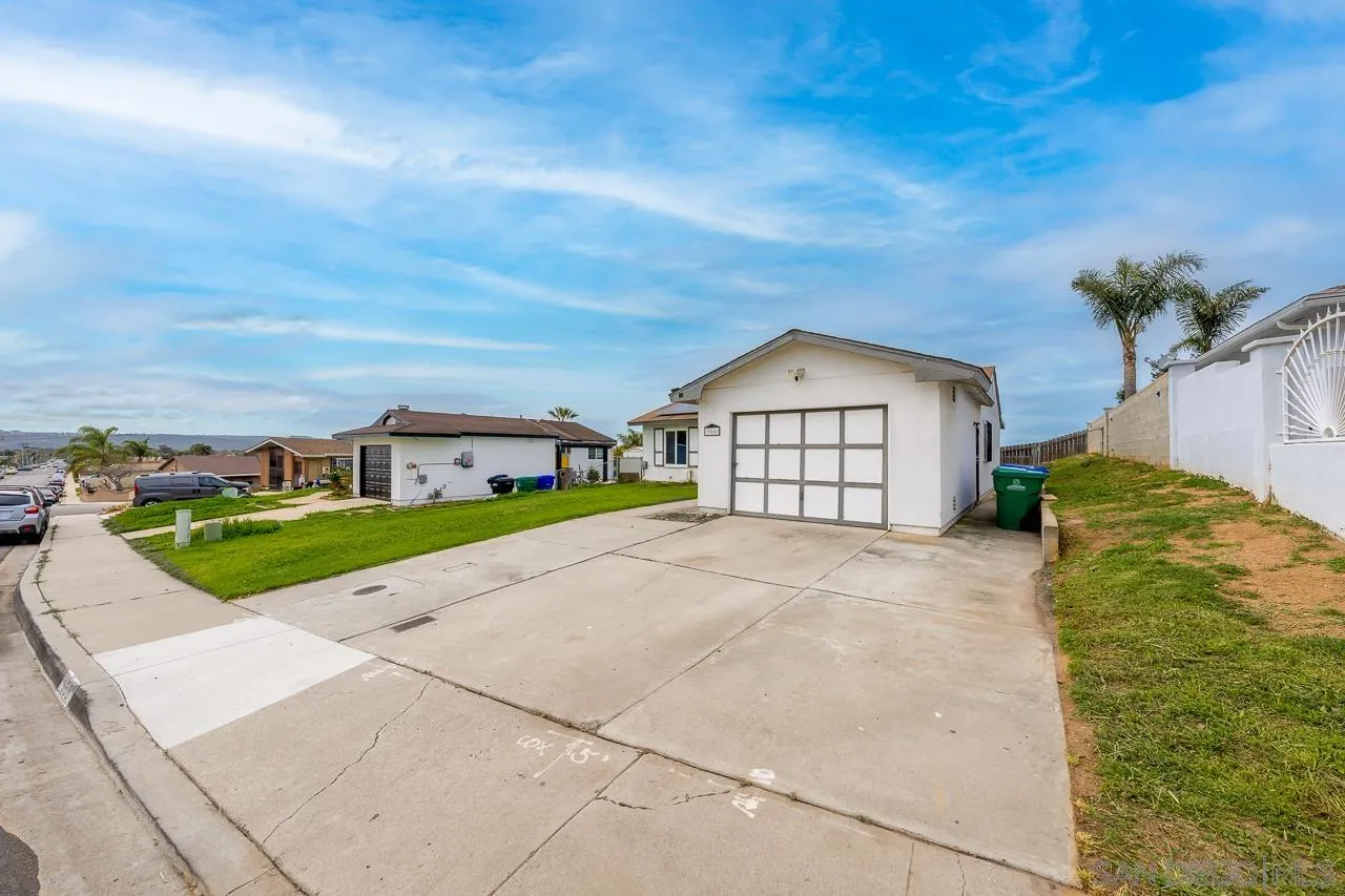 966 27th Street San Diego, CA 92154 - Photo 6 of 33 a front view of a house with a yard and garage