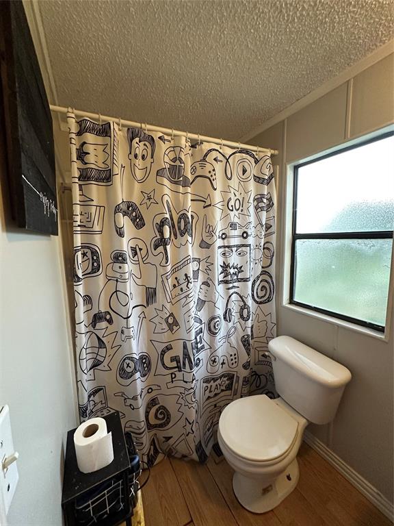 1048 Red Bird Seven Points, TX 75143 - Photo 26 of 28 a white toilet sitting next to a shower curtain