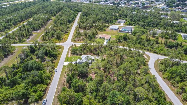 an aerial view of residential house with outdoor space and trees all around