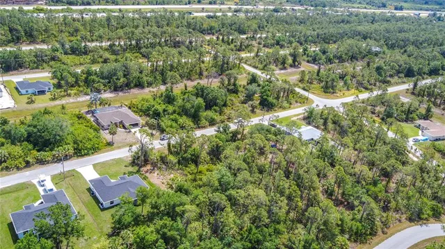 an aerial view of residential houses with outdoor space and trees