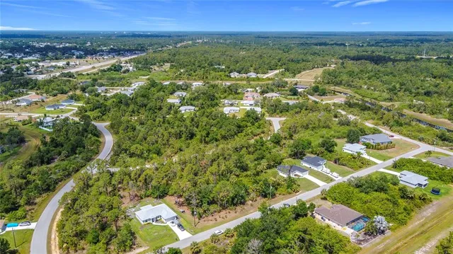 an aerial view of residential houses with outdoor space and trees