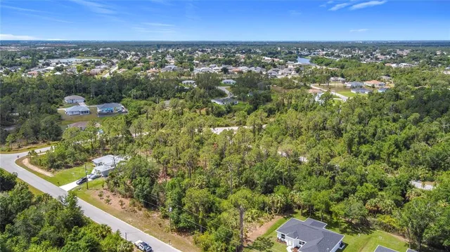 an aerial view of residential houses with outdoor space and trees