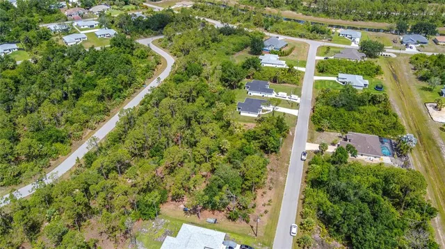 an aerial view of residential house with outdoor space and trees all around