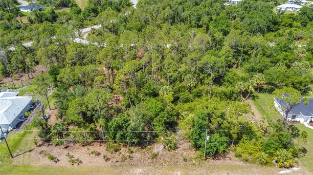 an aerial view of residential houses with outdoor space and trees all around