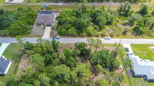 an aerial view of residential houses with outdoor space and trees