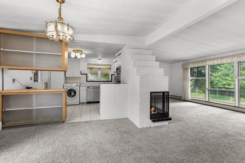 7 Ruth Drive Framingham, MA 01701 - Photo 4 of 33 a view of a livingroom with a fireplace a chandelier and window