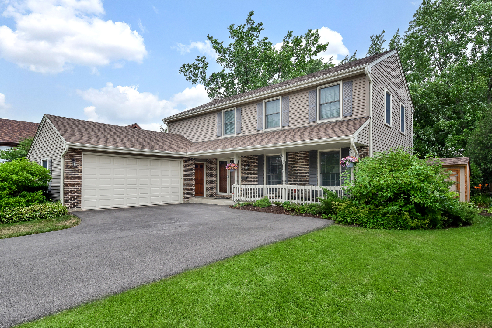 a front view of a house with a garden and yard