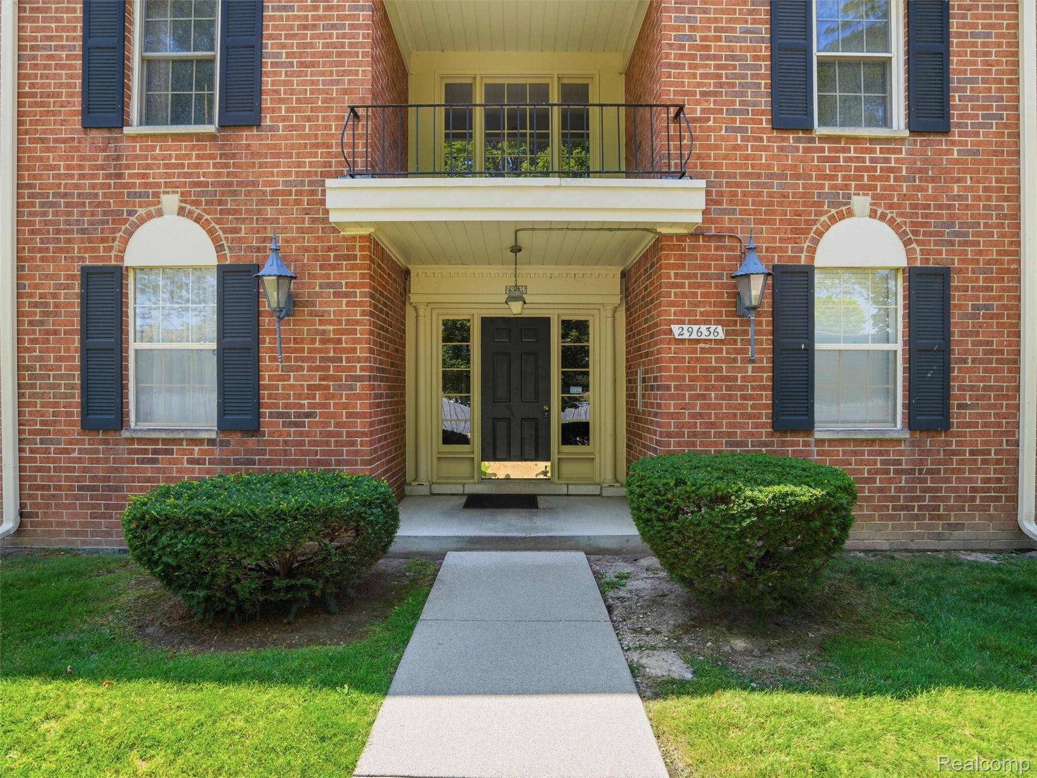 Brick facade with dark shutters and decorative arched window details