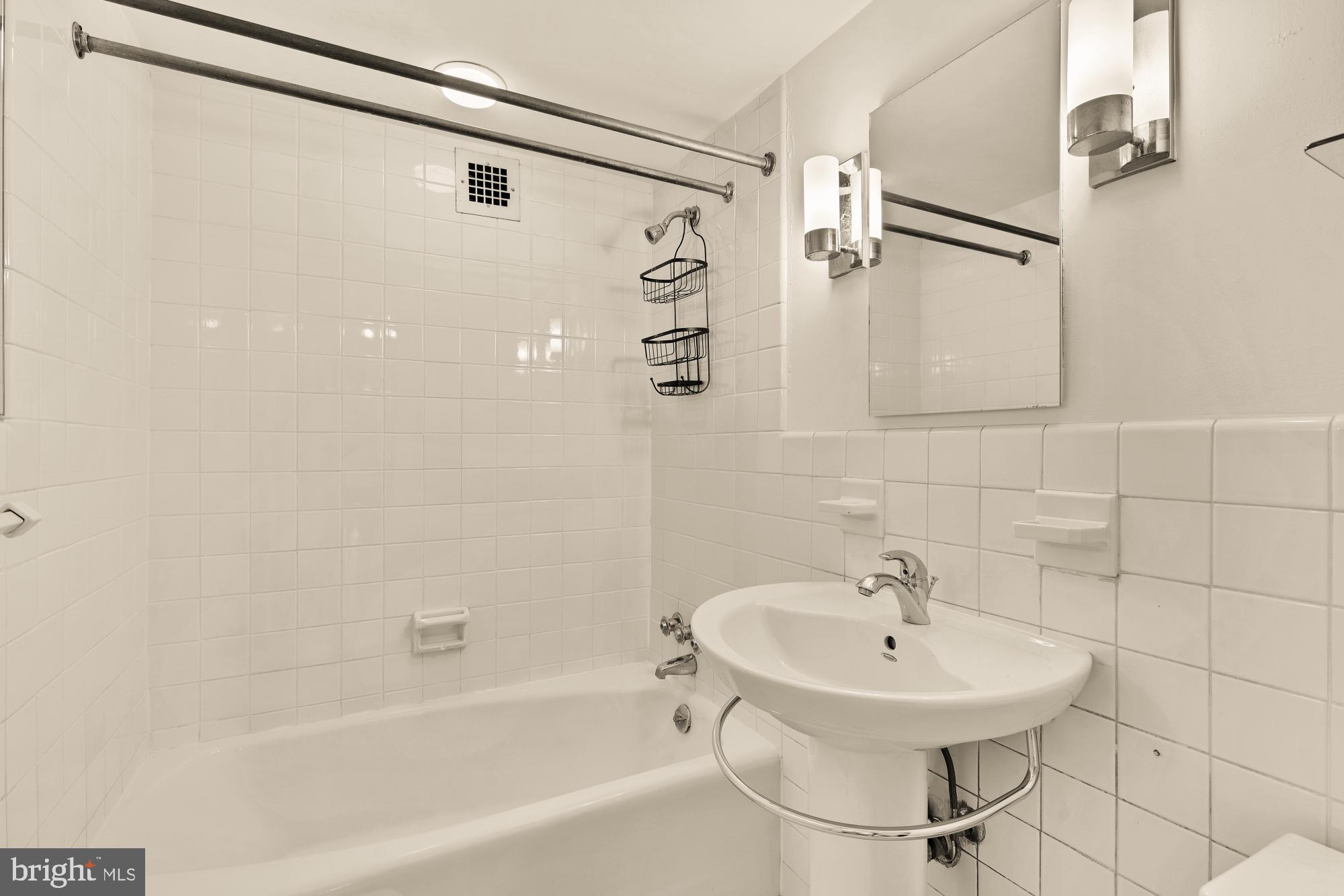 5100 Dorset Avenue, Unit 308 Chevy Chase, MD 20815 - Photo 16 of 31 a bathroom with a sink a mirror and a bathtub