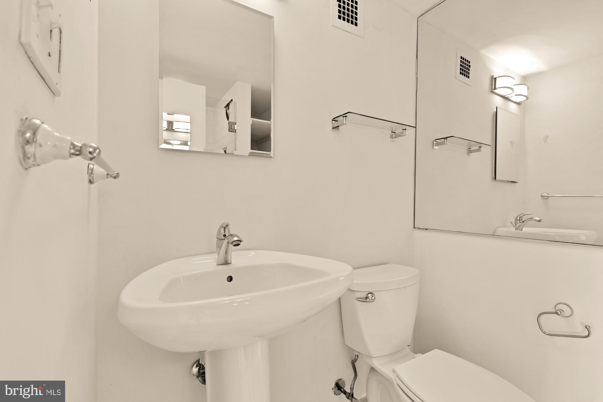 5100 Dorset Avenue, Unit 308 Chevy Chase, MD 20815 - Photo 20 of 31 a bathroom with a sink a toilet and a mirror