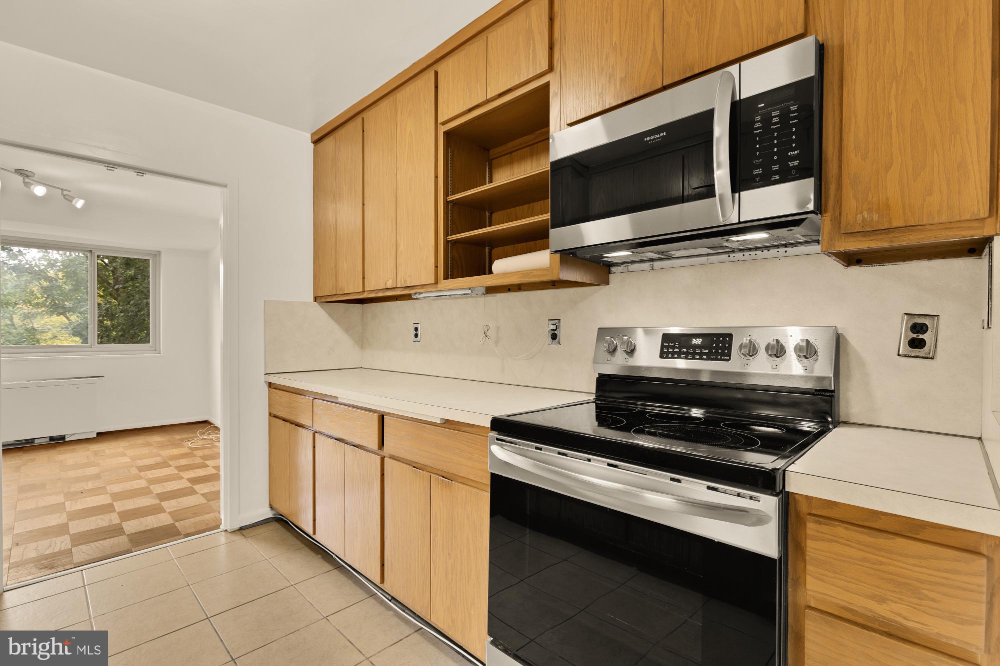 5100 Dorset Avenue, Unit 308 Chevy Chase, MD 20815 - Photo 7 of 31 a kitchen with stainless steel appliances a stove a microwave and cabinets