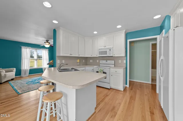 a bedroom with a large bed a chandelier and windows
