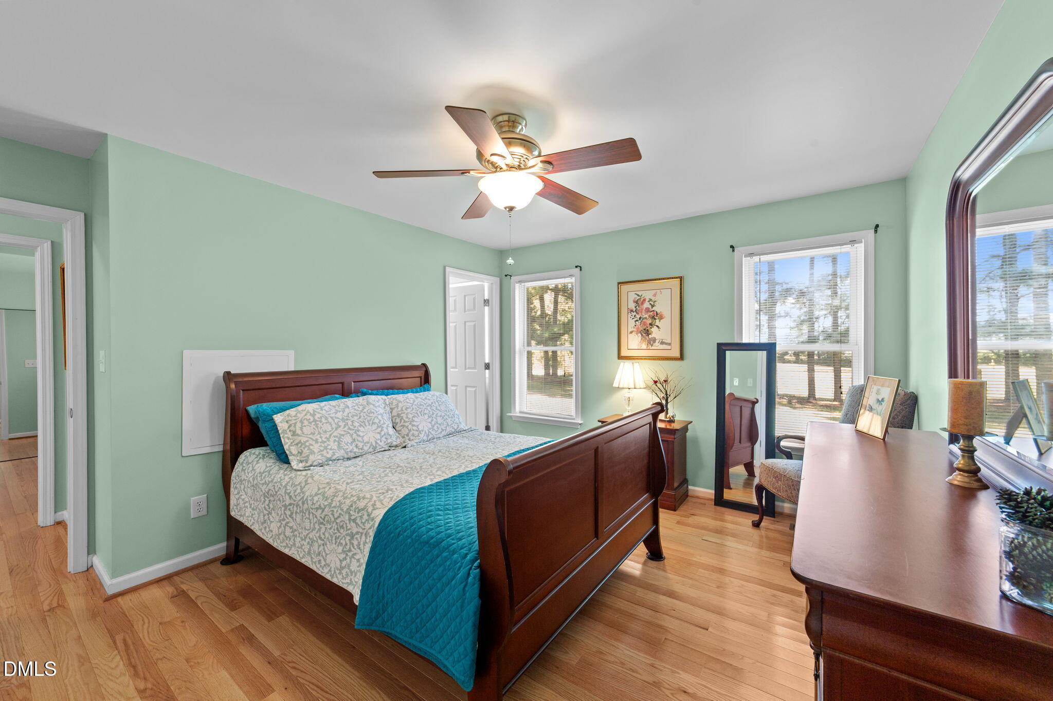 1208 Peach Orchard Road Four Oaks, NC 27524 - Photo 31 of 63 a bedroom with a large bed a chandelier and windows