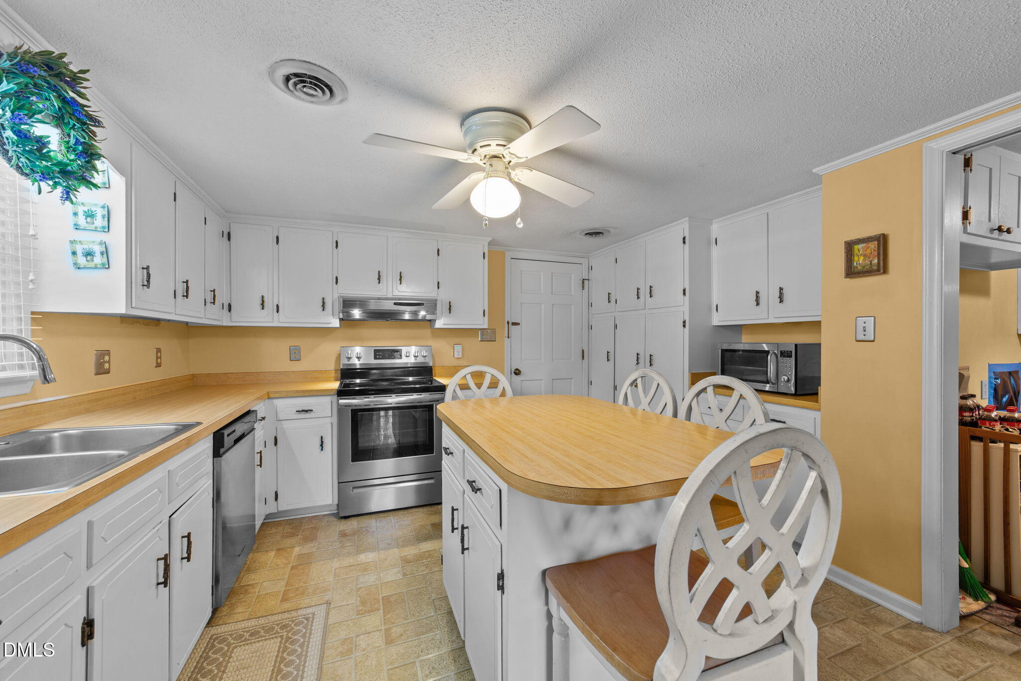 1208 Peach Orchard Road Four Oaks, NC 27524 - Photo 59 of 63 a kitchen with a stove a sink and a refrigerator