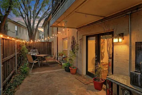a view of a patio with table and chairs and wooden fence