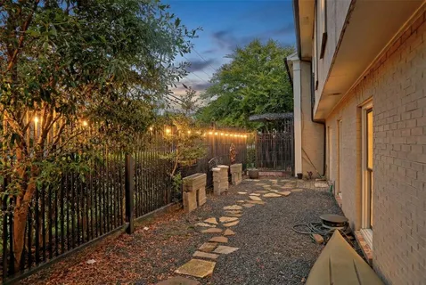 a view of a patio with table and chairs and wooden fence