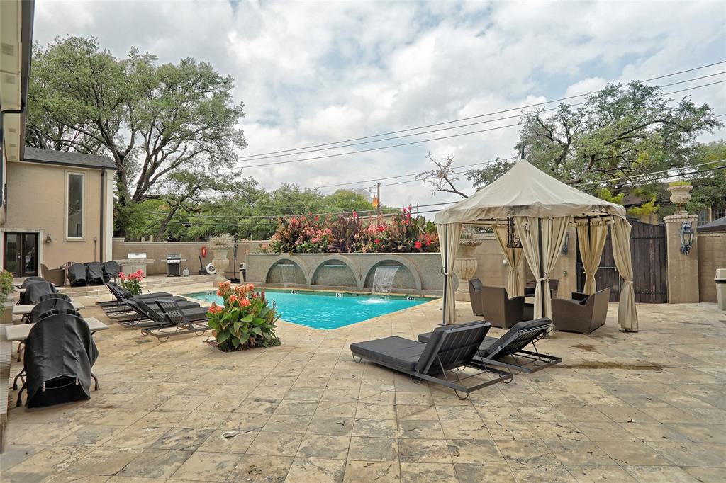 7736 Meadow Road, Unit 102 Dallas, TX 75230 - Photo 24 of 25 Pool area features cabana and lounge chairs.