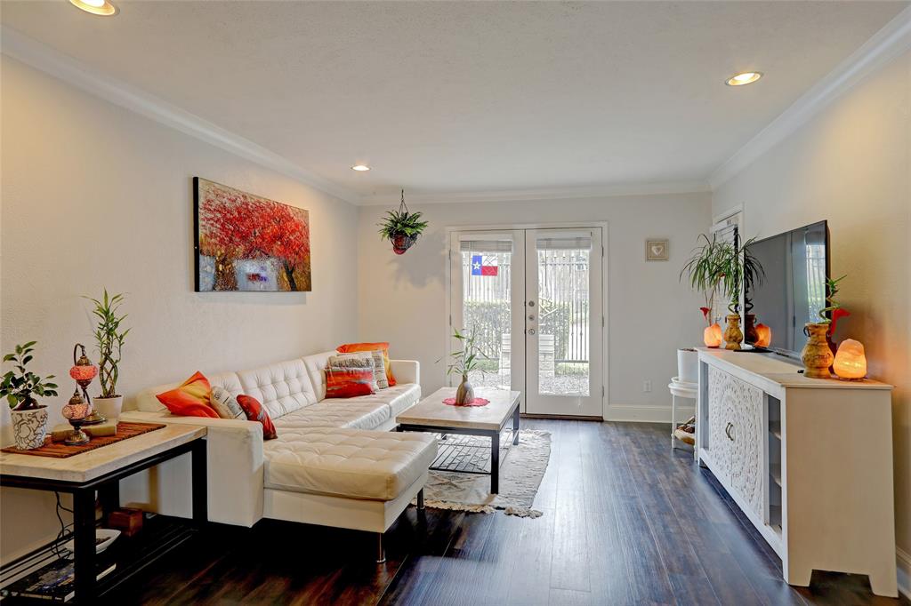 7736 Meadow Road, Unit 102 Dallas, TX 75230 - Photo 3 of 25 Sunlit living room with hardwood floors and crown molding