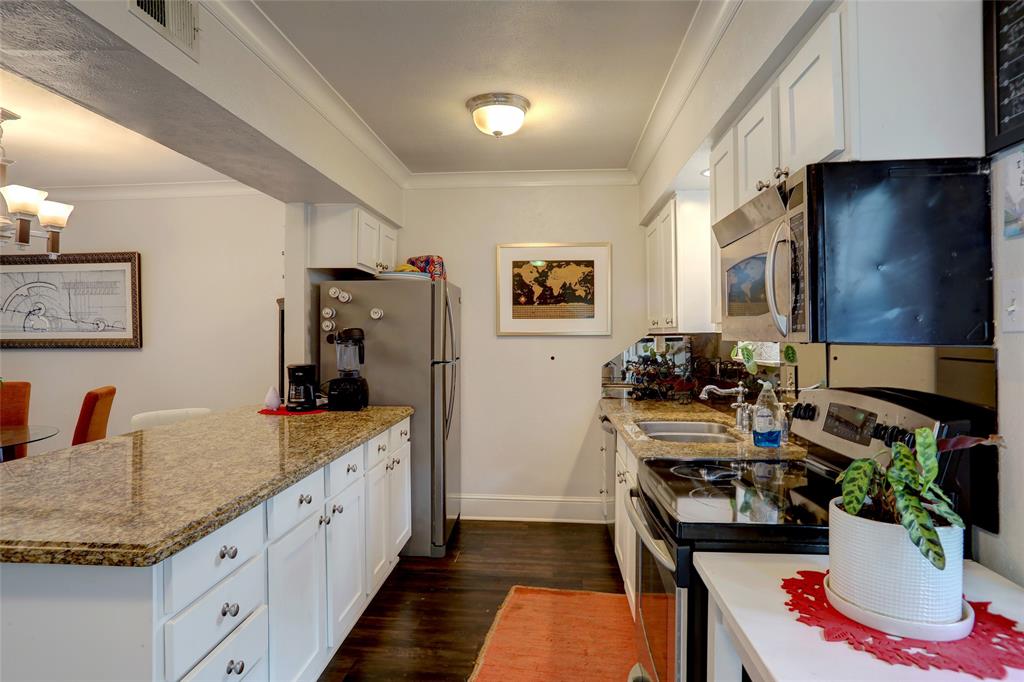 7736 Meadow Road, Unit 102 Dallas, TX 75230 - Photo 9 of 25 Granite counters, white cabinetry, and plenty of workspace