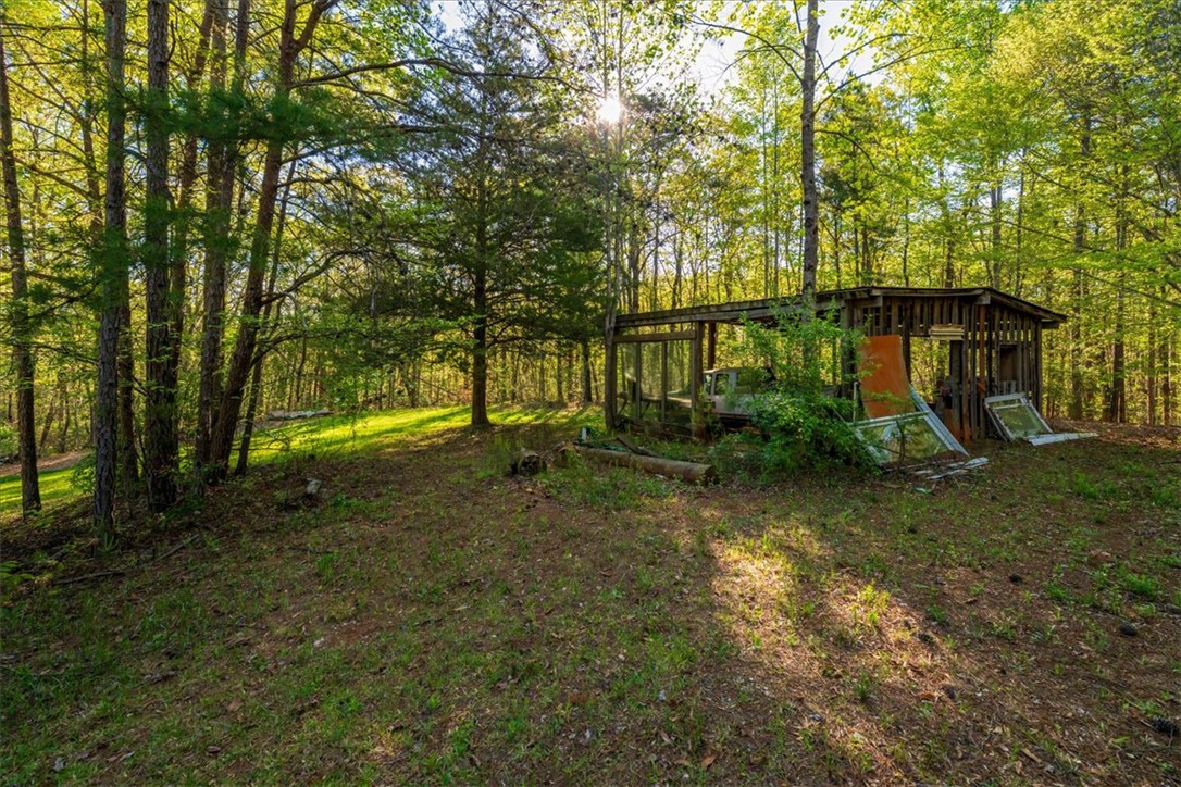 930 Nimmons Bridge Road Salem, SC 29676 - Photo 13 of 19 This tranquil wooded lot offers a rustic outbuilding amidst lush greenery, perfect for a peaceful retreat.
