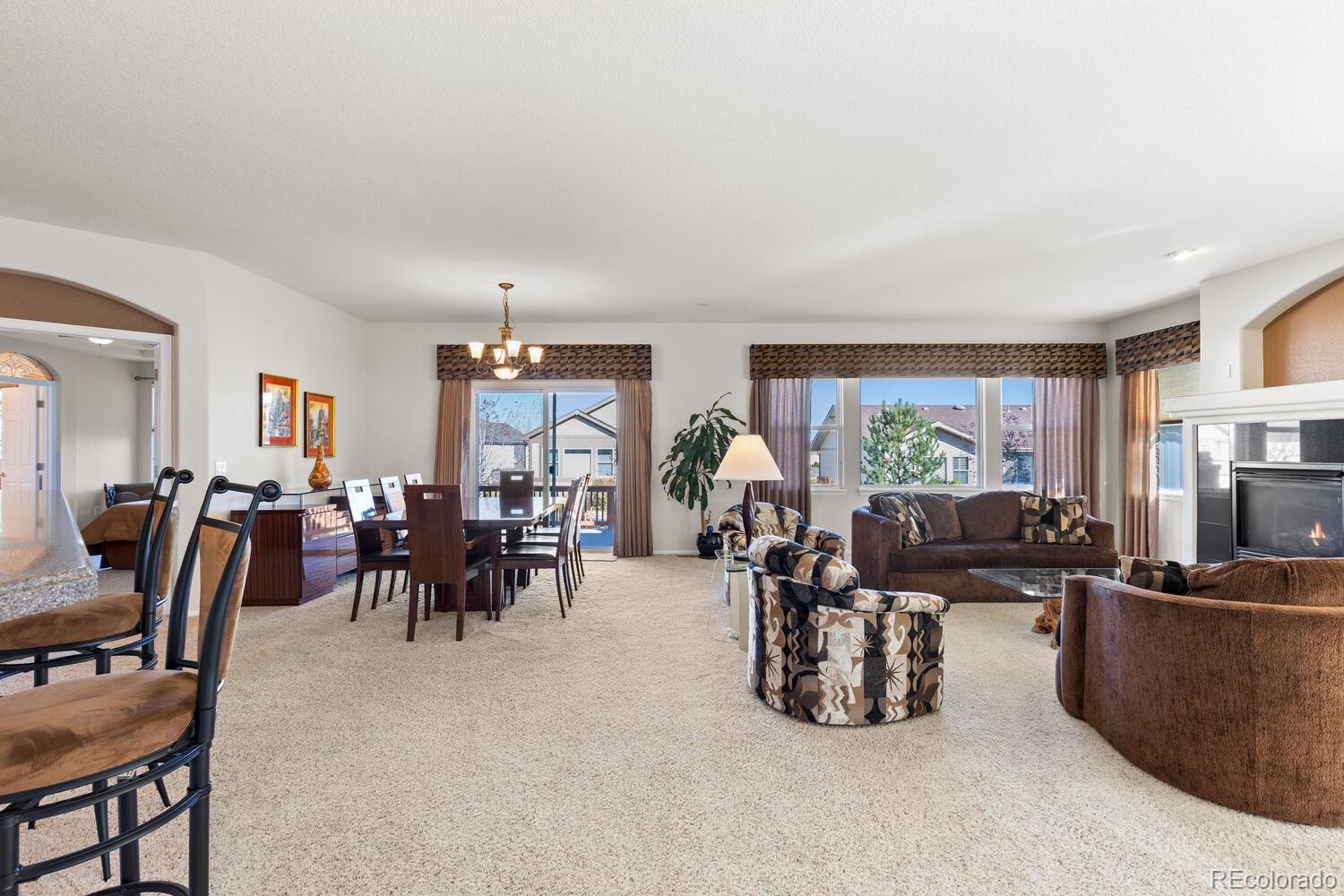 8322 South Quatar Circle Aurora, CO 80016 - Photo 15 of 47 a living room with furniture a large window and a flat screen tv