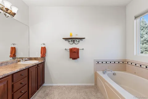 a bathroom with a tub sink and mirror