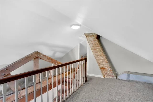 a view of staircase with railing and white walls