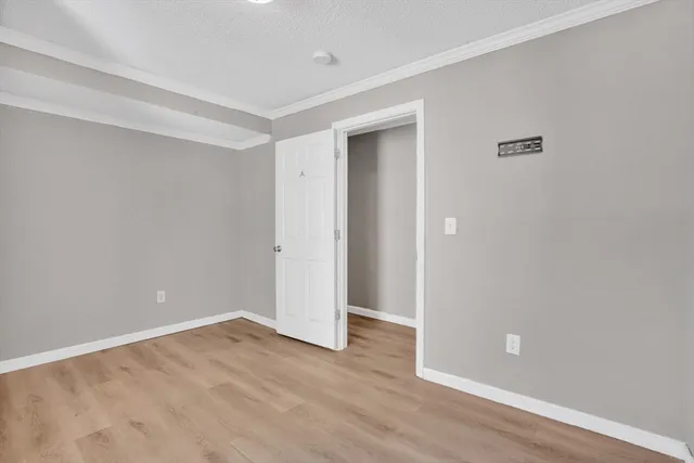 an empty room with wooden floor and closet