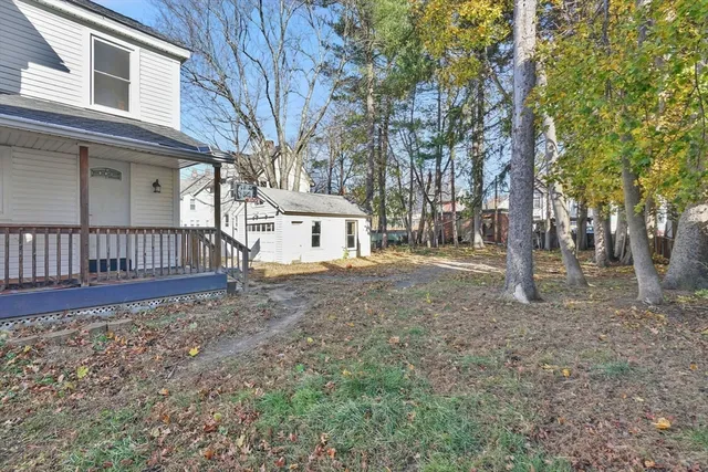 a view of a house with backyard and trees