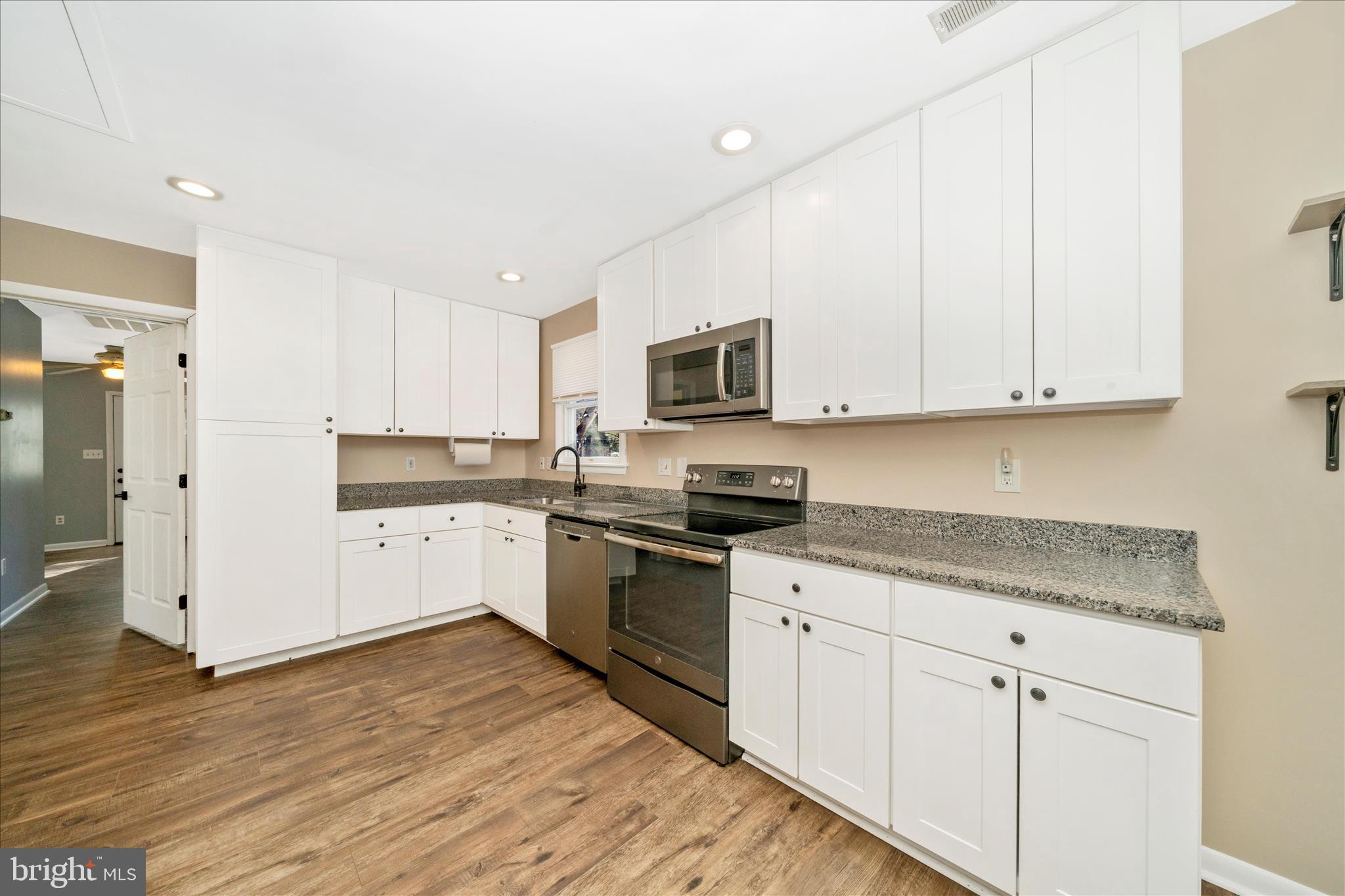 923 Klees Mill Road Westminster, MD 21157 - Photo 15 of 52 a kitchen with granite countertop white cabinets and white appliances