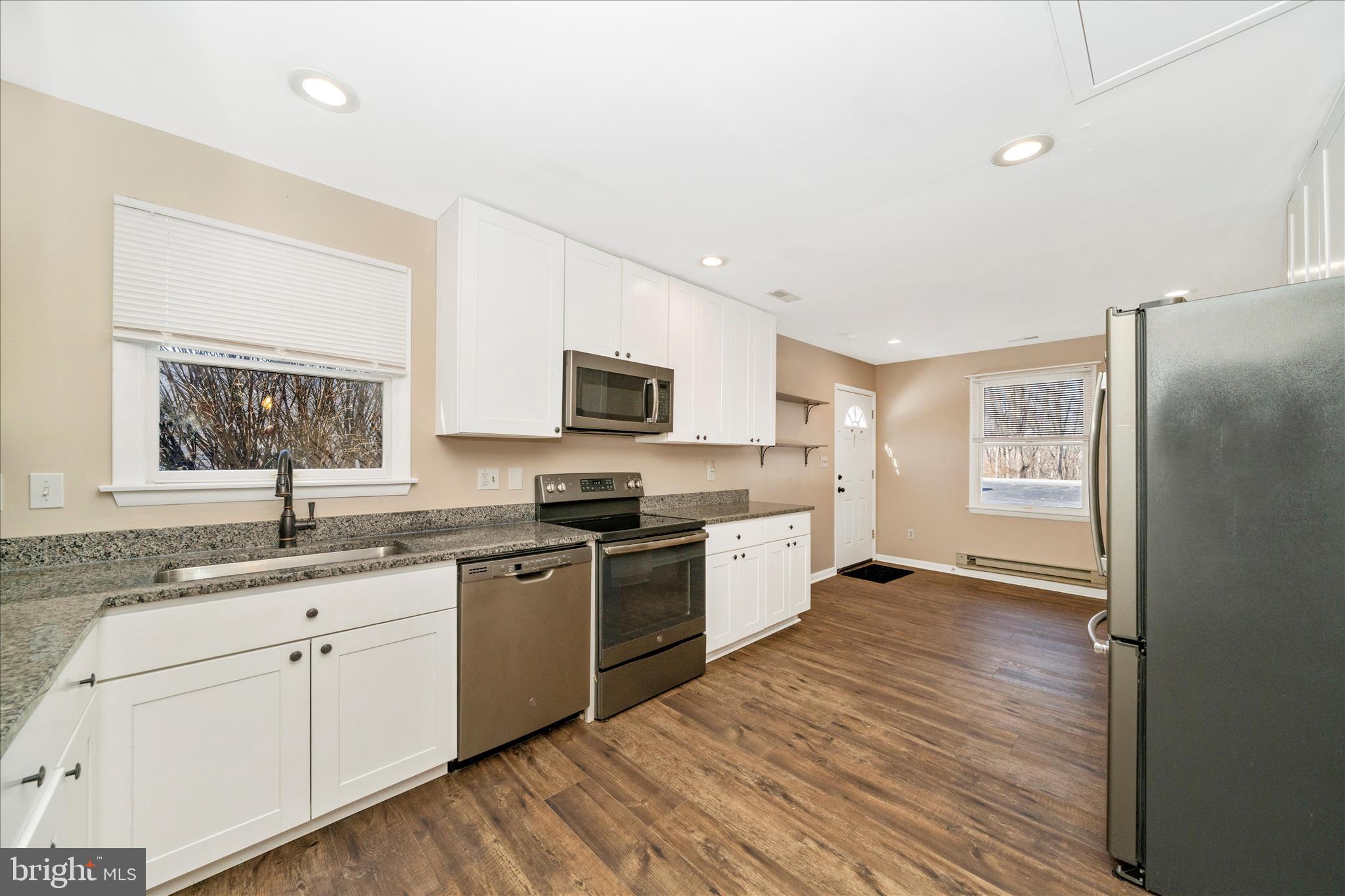 923 Klees Mill Road Westminster, MD 21157 - Photo 19 of 52 a large kitchen with cabinets wooden floor and stainless steel appliances