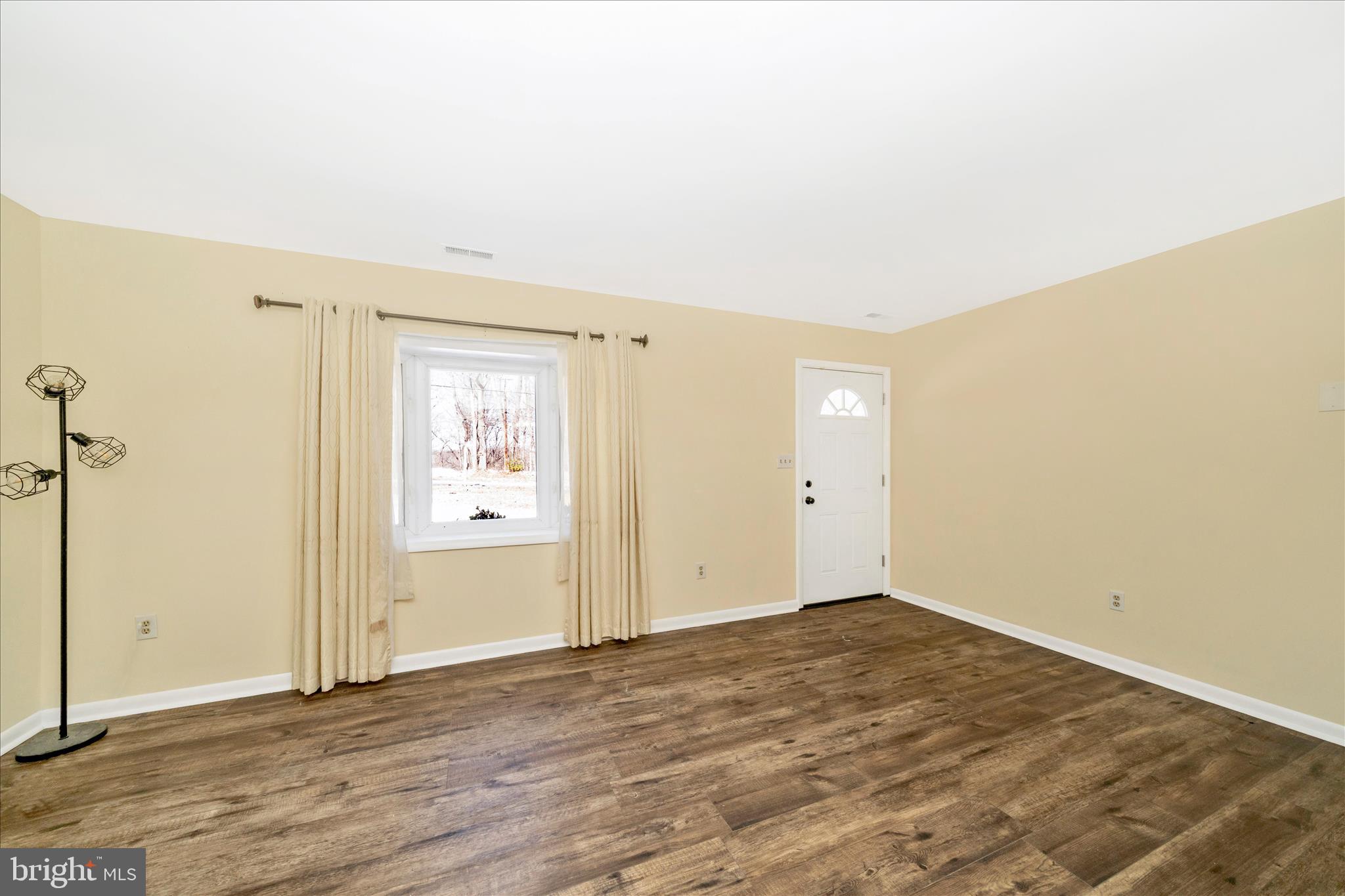 923 Klees Mill Road Westminster, MD 21157 - Photo 6 of 52 an empty room with wooden floor and windows