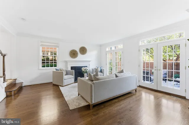 a living room with furniture a fireplace and a large window